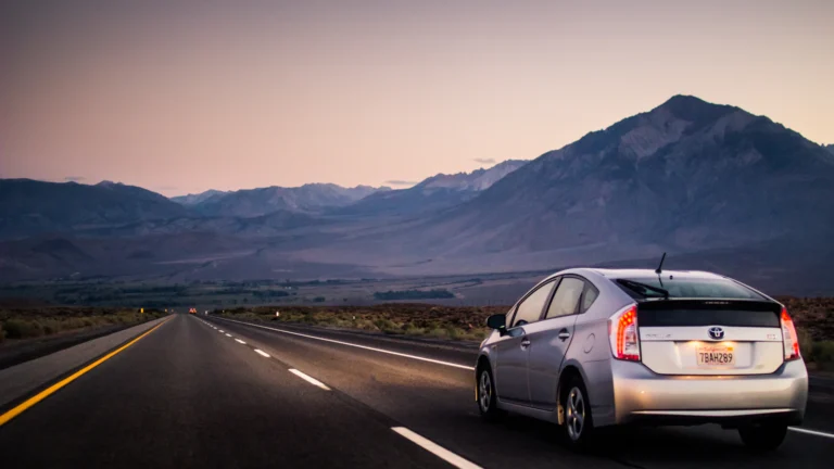Car driving on an open highway with mountains in the background